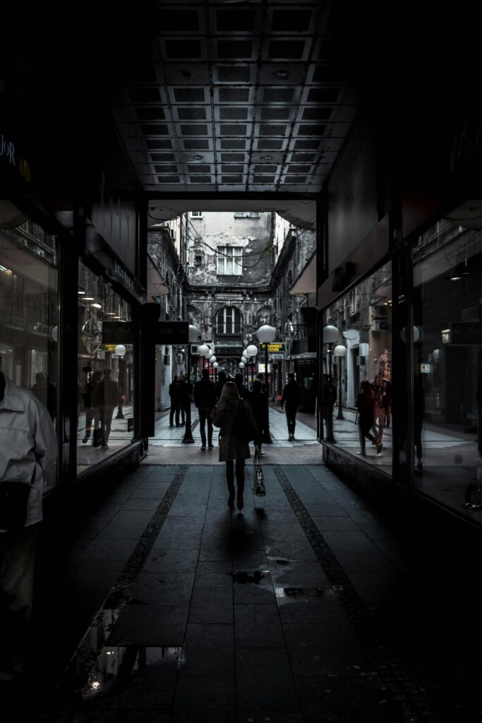 Moody alleyway in Belgrade's historic district with silhouettes of people walking, offering a glimpse of urban life.